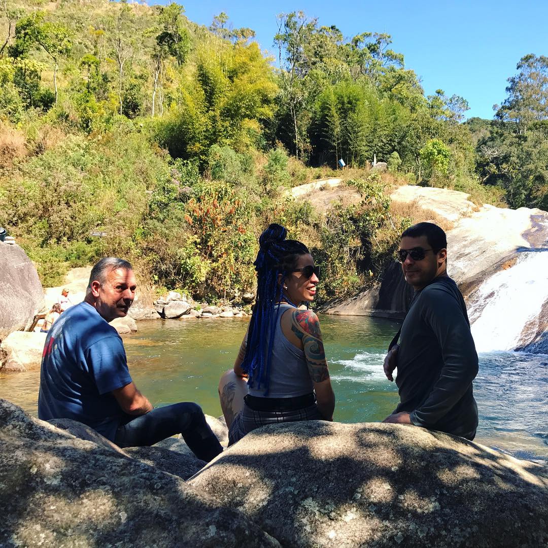 Três pessoas com o p[e na cachoeira