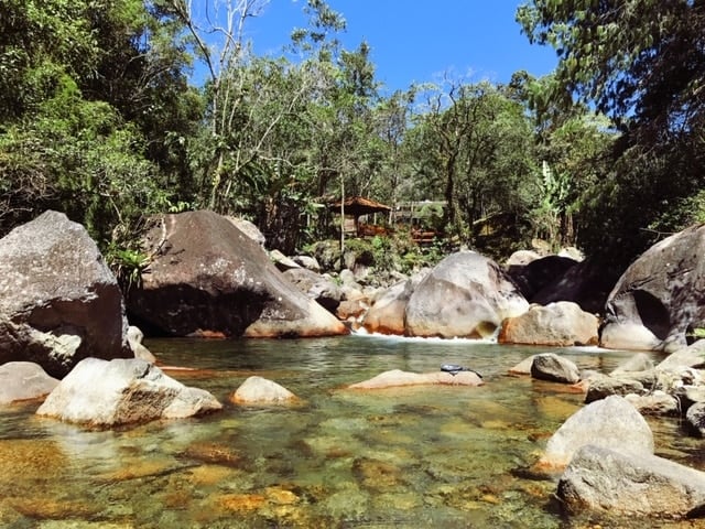 Rio de águas cristalinas descendo entre pedras na pousada jardim das aguas