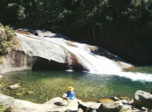 Mulher sentada na cachoeira