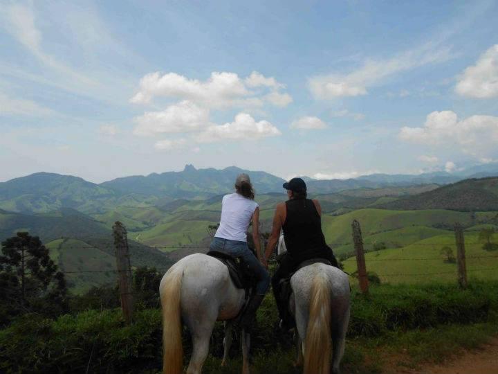 Casal à cavalo comtemplando as montanhas da serra da Mantiqueira