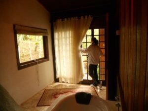 Mulher aprecinado a vista das janelas onde est&aacute; aBanheira do chal&eacute;