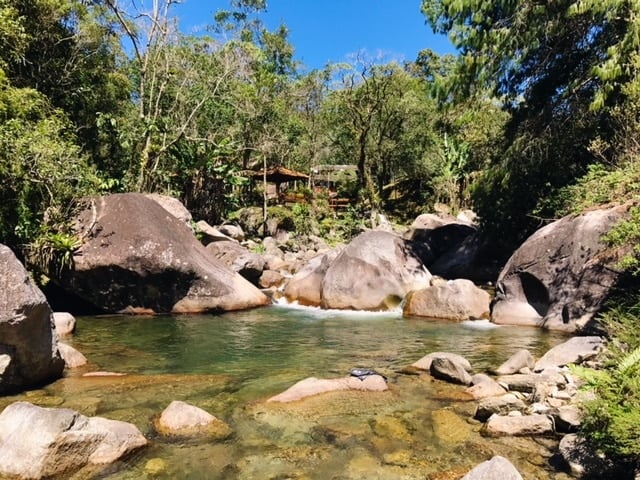 Rio de águas cristalinas entre pedras com piscina natural de águas limpas em Maromba