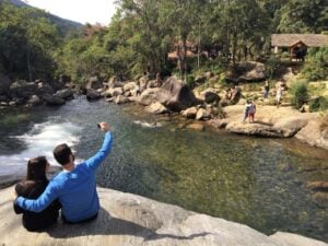 Casal sentado na cachoeira do Escorrega em Visconde de Maua