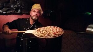 Homem com pizza na forma em Visconde de Mauá