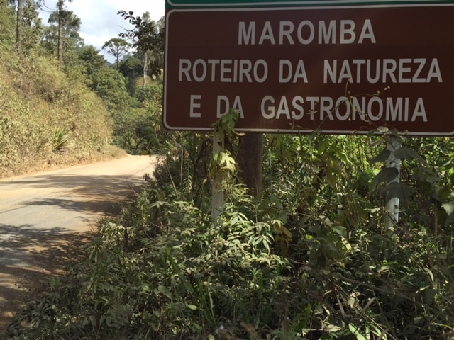 Estrada de cascalho com placa da Vila da Maromba