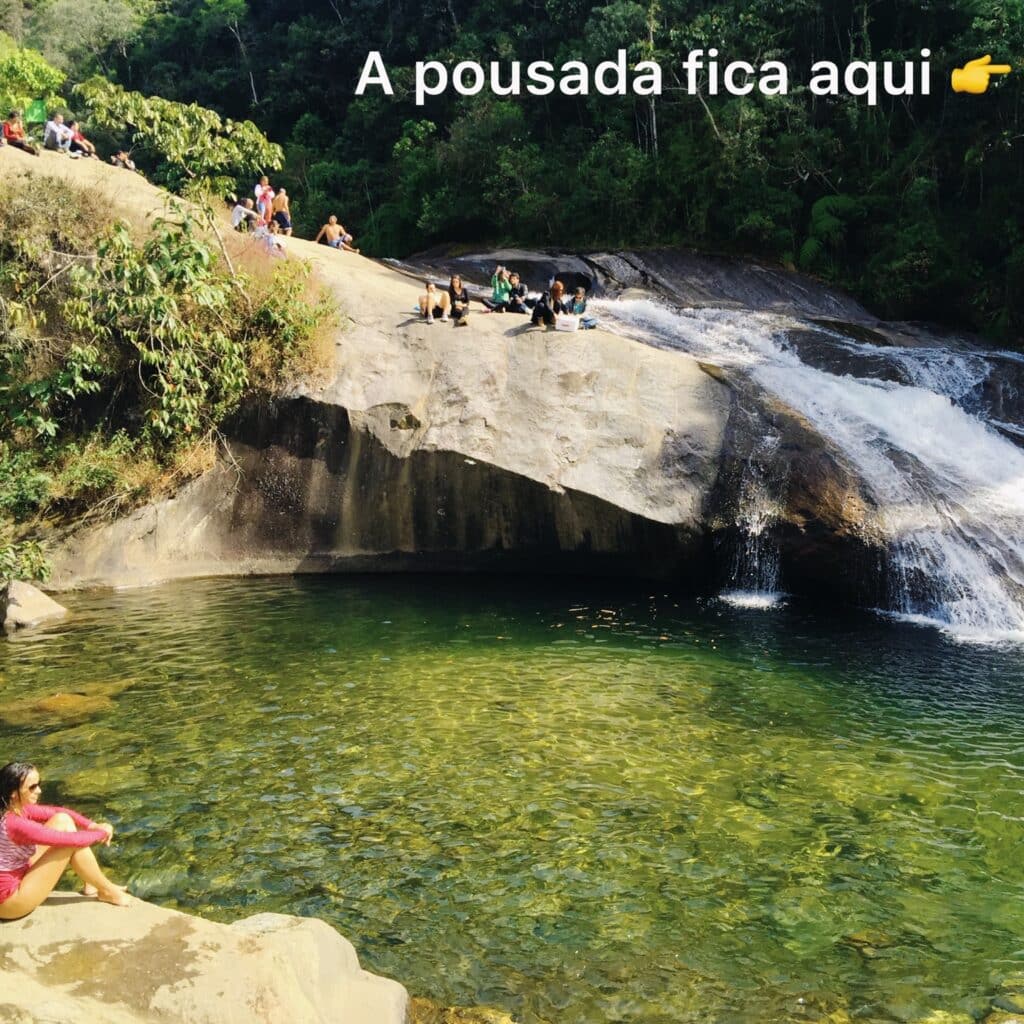Moça sentada na pedra da cachoeira em Visconde de Mauá