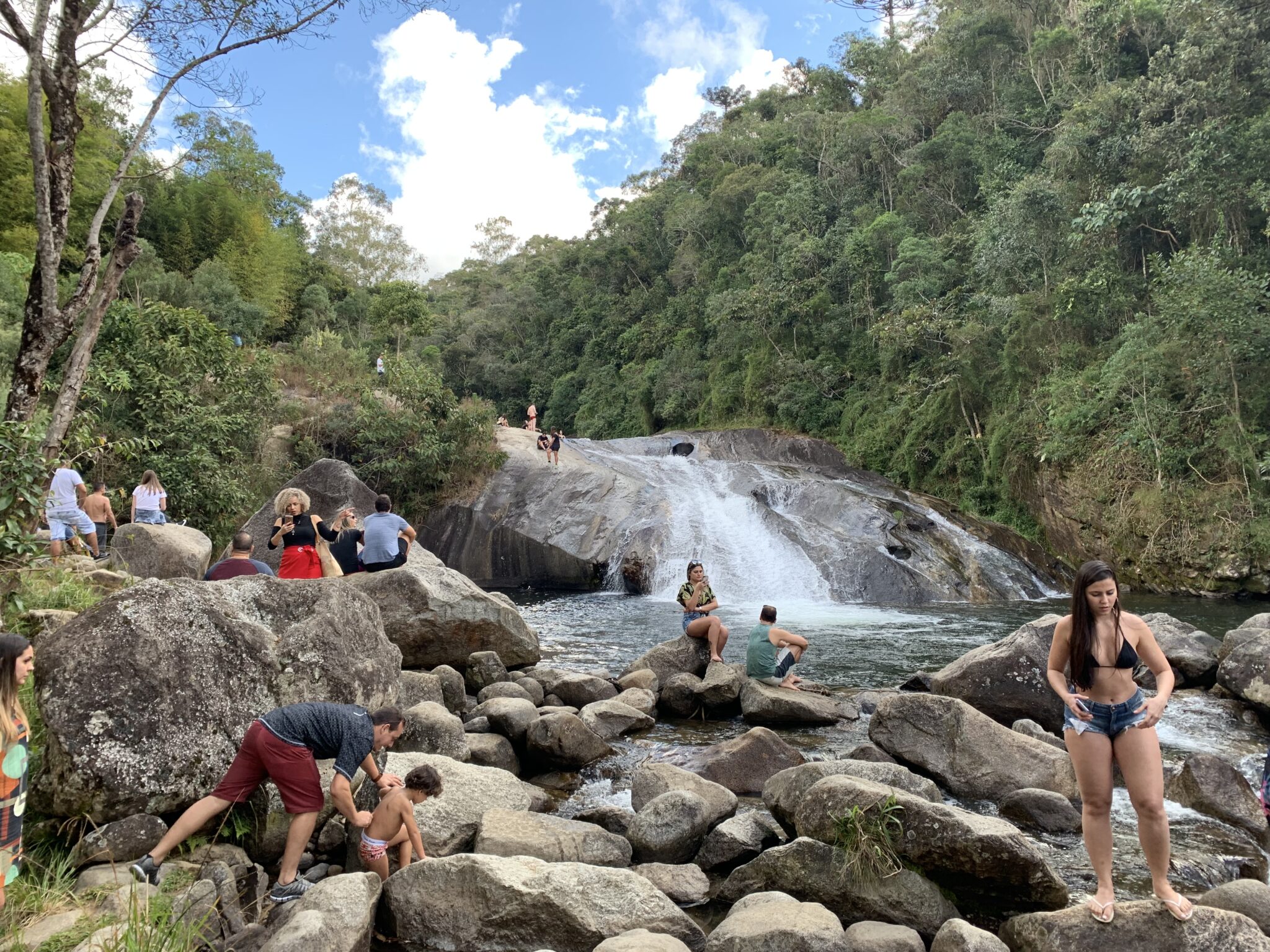 Turistas curtindo o visual de uma cachoeira em Visconde de Maua