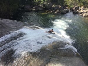 Homem deslizando numa pedra da cachoeira em Visconde de Mauá