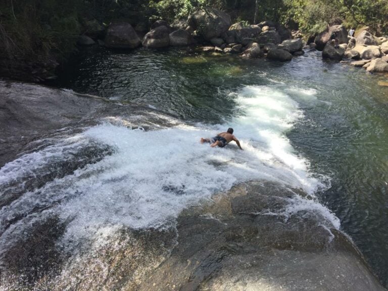 Homem deslizando numa pedra da cachoeira em Visconde de Mauá