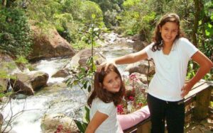 Duas crianças felizes brincando na beira do rio em Visconde de