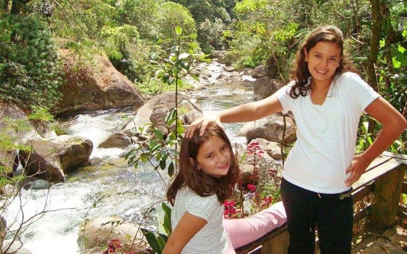 Duas crianças felizes brincando na beira do rio em Visconde de