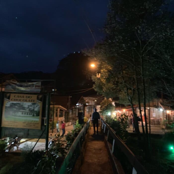 Pessoas passeando a noite na vila de Maringá em Visconde de Mauá