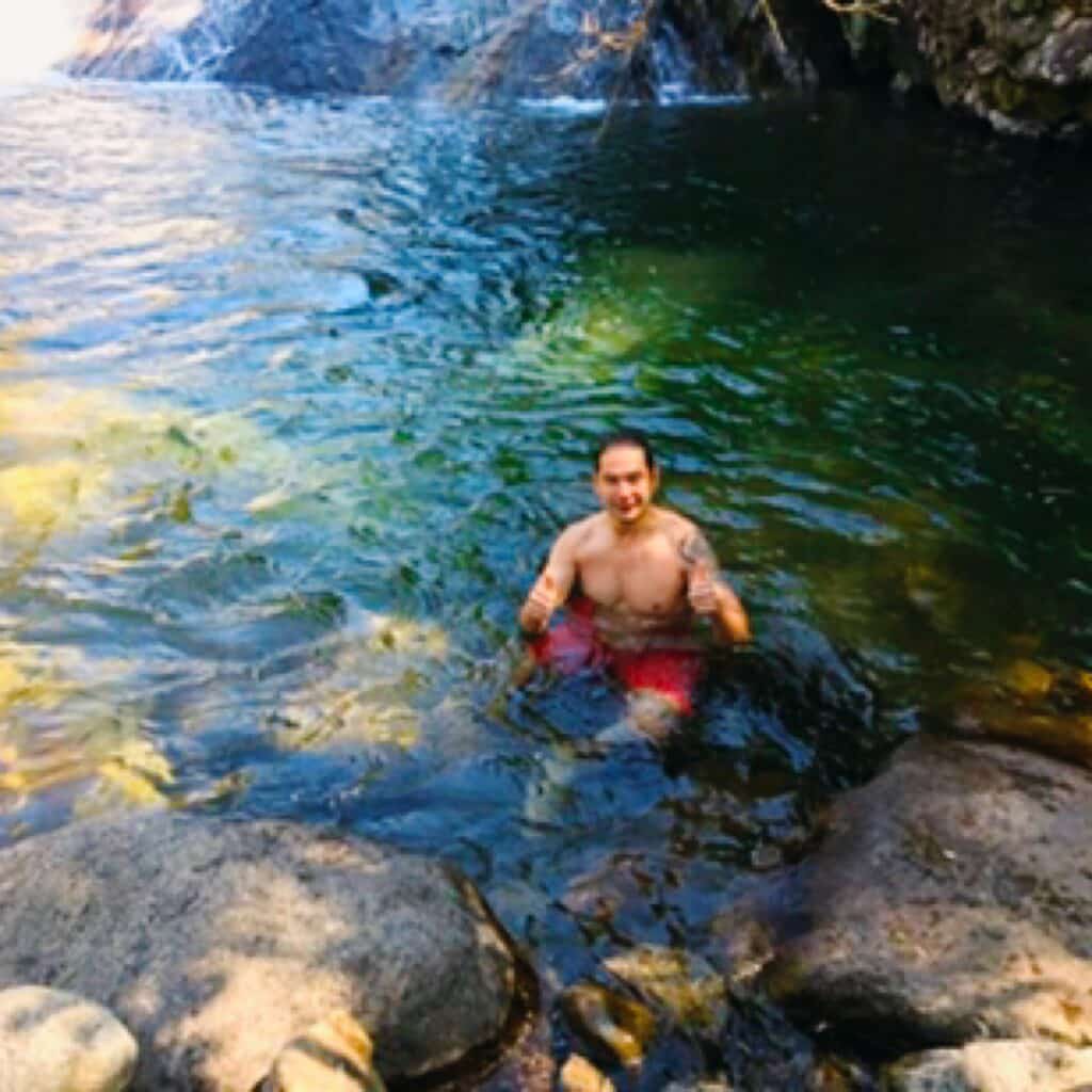 Homem dentro da água em uma cachoeira em Visconde de Maua