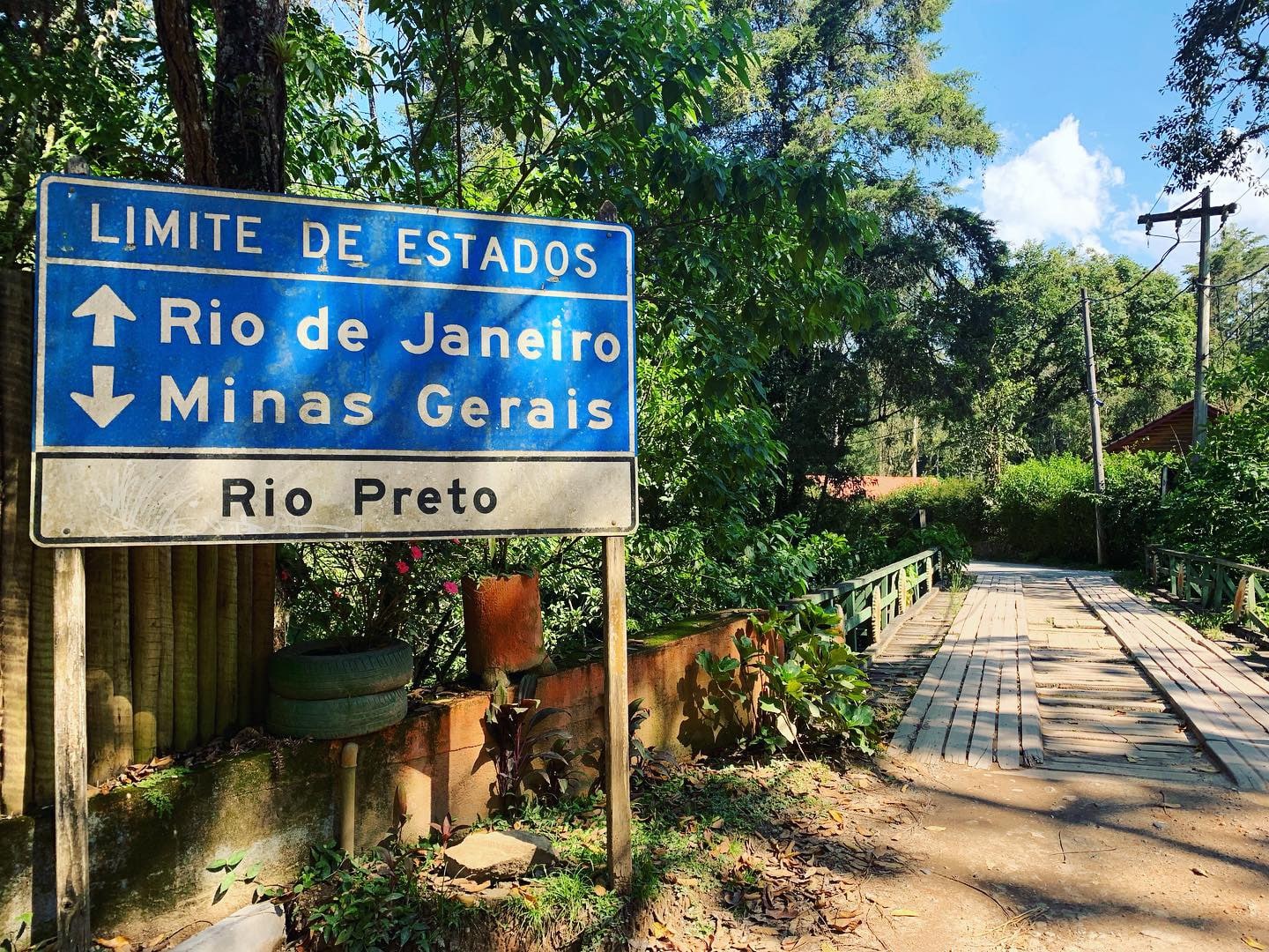 Placa sinalizando a divisa de estadp de Minas gerais com Rio de Janeiro na estarda para Visconde de Maua