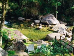Duas cadeira na margem de uma piscina natural na Vila da Maromba