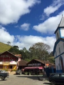Praça da Maromba em Visconde de Mauá com carros e a Igreja ao lado