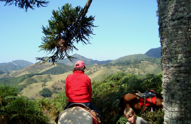 Mulher passeando a cavalo coma serra da Mantiqueira ao fundo