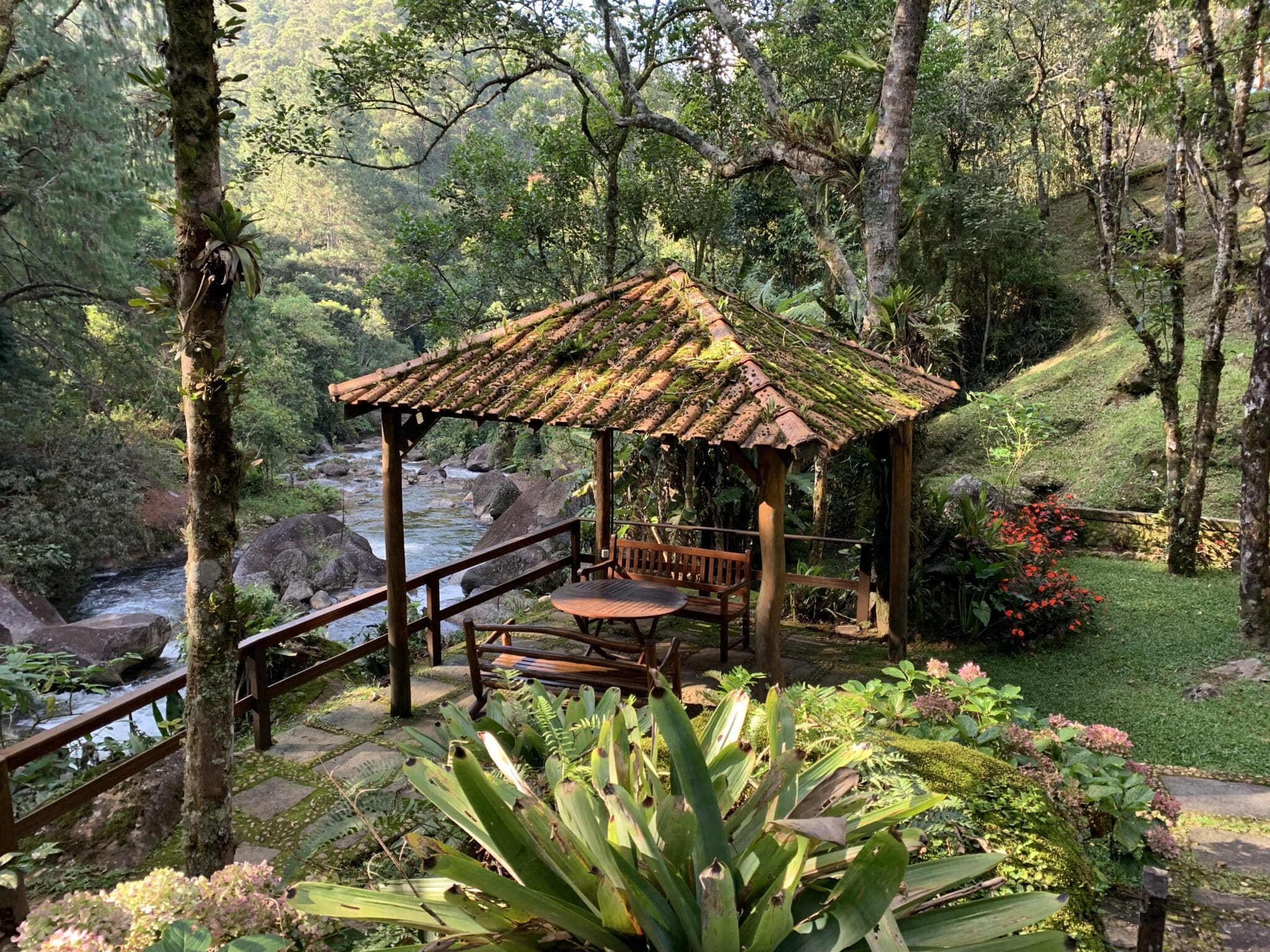 Jardim com deck ao lado do rio em Visconde de Mauá.