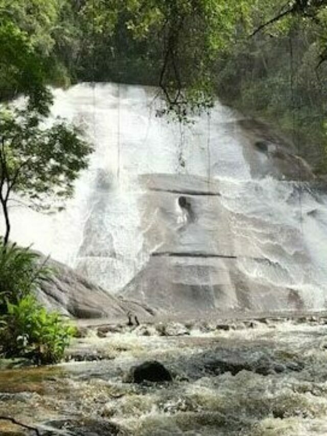 Cachoeira num paredão alto de pedra em Visconde de Mauá em meio mata ciliar