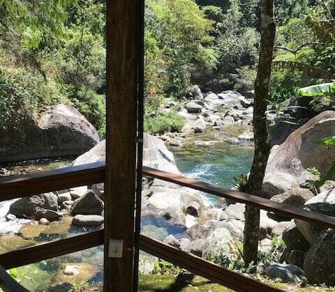 Varanda da pousada com rio ao fundo em Visconde de Mauá