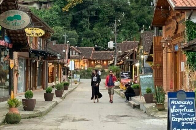 Casal passeando entre lojas e restaurantes na vila de Maringá.