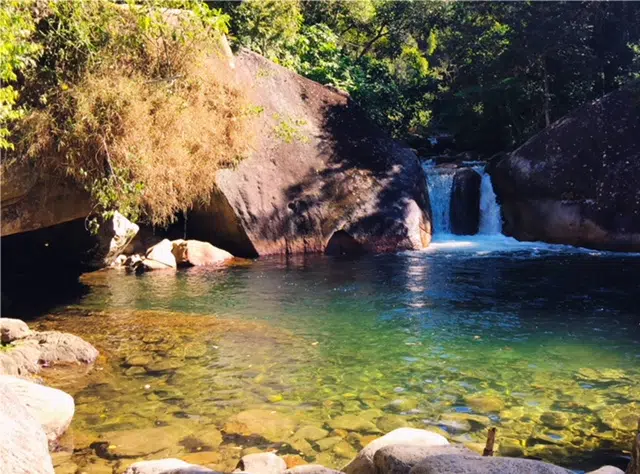Piscina natural de águas transparentes formado por uma cachoeira em Visconde de Maua