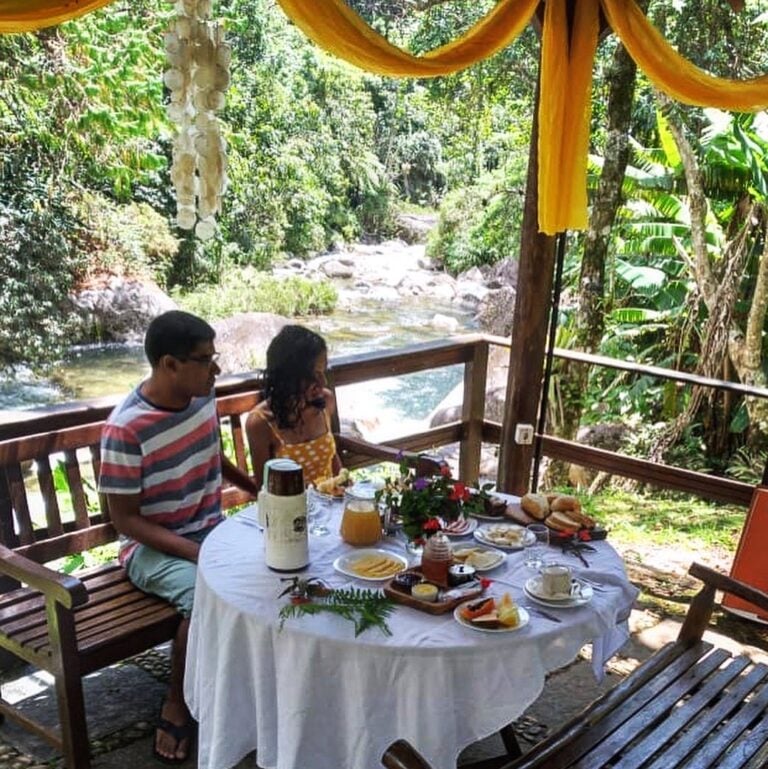 Casal na mesa ao lado da cachoeira